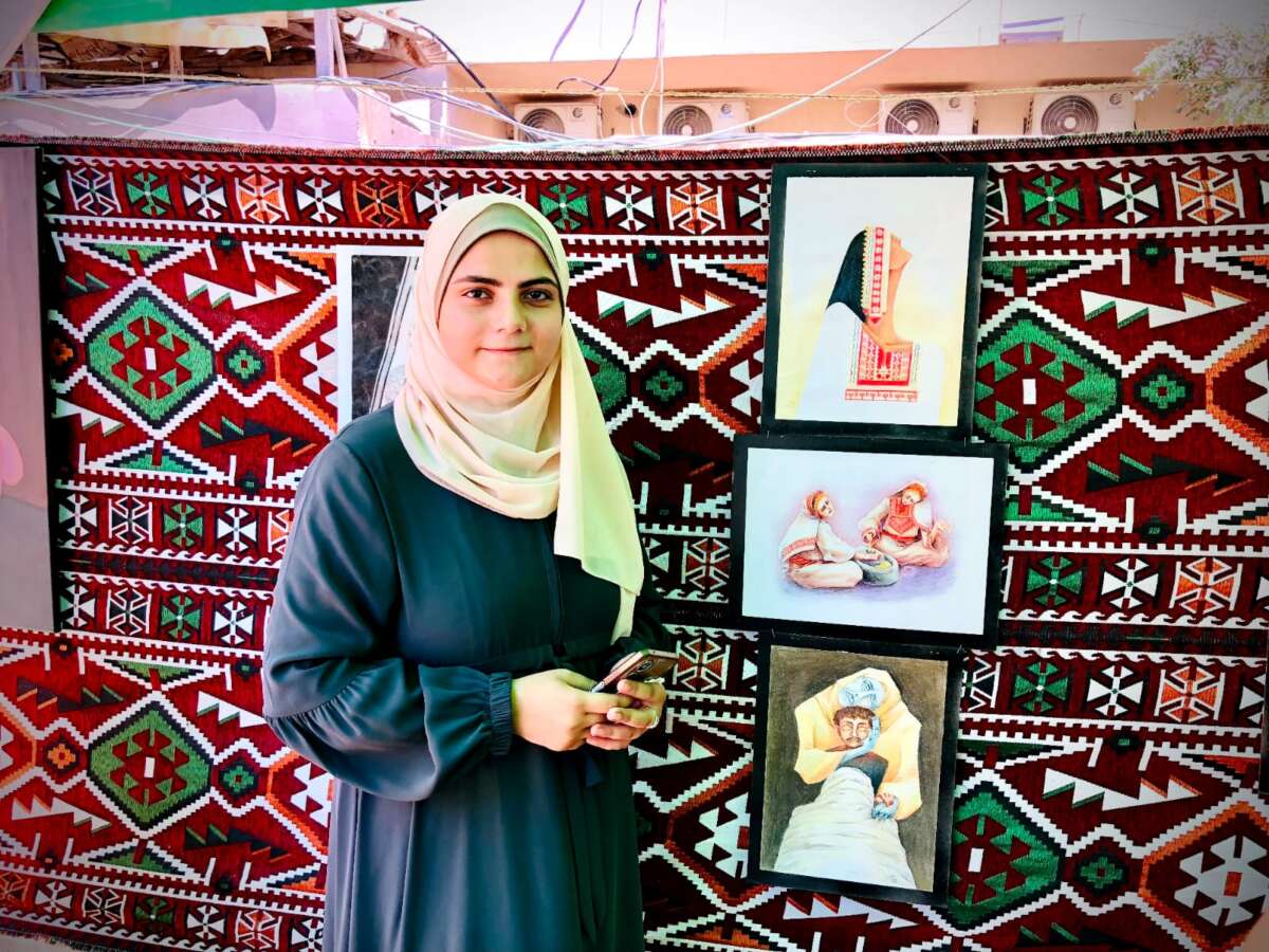 Inas Rayyan se muestra con sus tres obras de arte presentadas en la exposición Aphenix, una imagen de una mujer que usa ropa palestina tradicional que mira hacia arriba, una imagen de dos personas alrededor de un saco de comida y otra imagen que muestra a una persona con un tinte gris con alguien cuyo torso está cubierto de una cubierta.