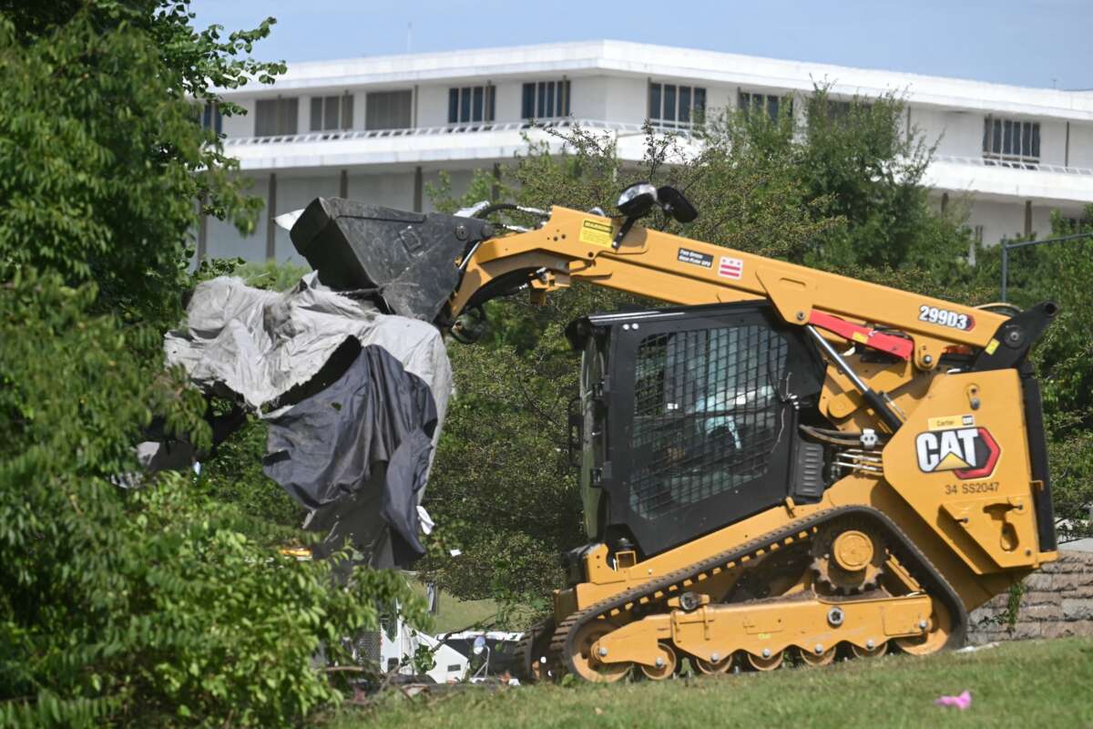D.C. city workers dismantle tents and remove personal belongings during a sweep of a homeless encampment in the Foggy Bottom neighborhood in Washington, D.C., on August 14, 2025.