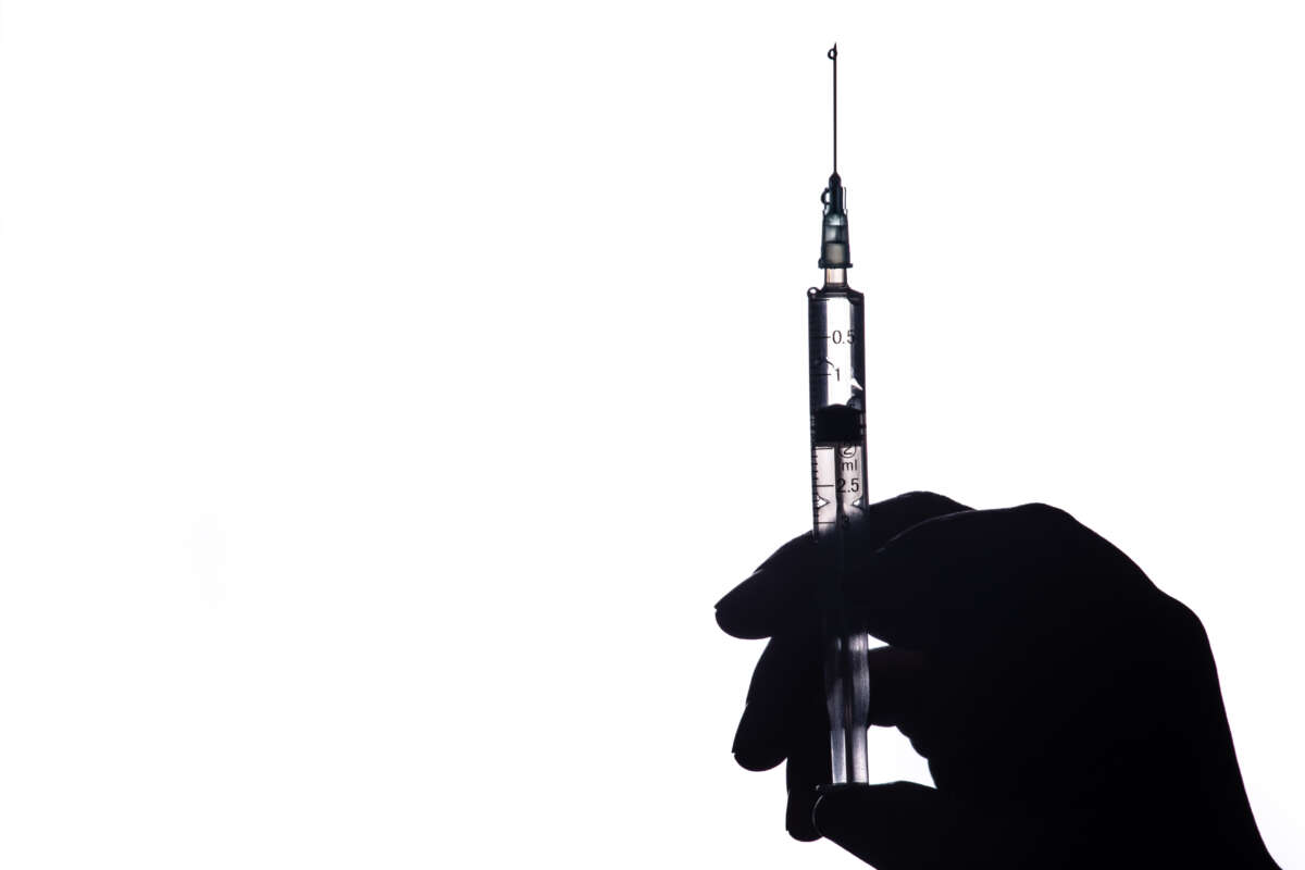 human hand holding a syringe