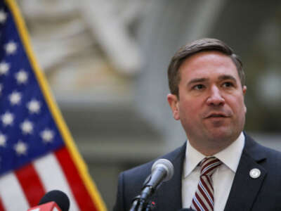 Missouri Attorney General Andrew Bailey close picture with the American flag peaking on the left side of the image.