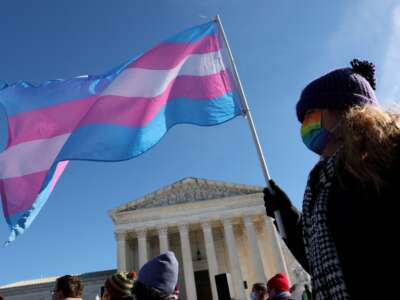 A trans rights supporter takes part in a rally outside of the Supreme Court as the high court hears arguments in a case on transgender health rights on December 4, 2024, in Washington, D.C.