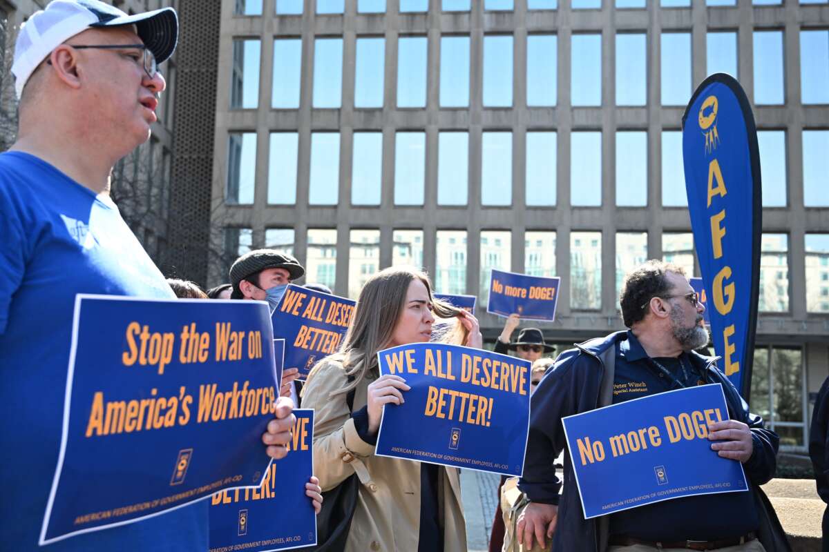 Protesters hold signs in solidarity with the American Federation of Government Employees of District 14 at a rally in support of federal workers at the Office of Personnel Management in Washington, D.C., on March 4, 2025. Since his inauguration, Donald Trump has moved to unilaterally dismantle federal agencies and fired thousands of government workers.