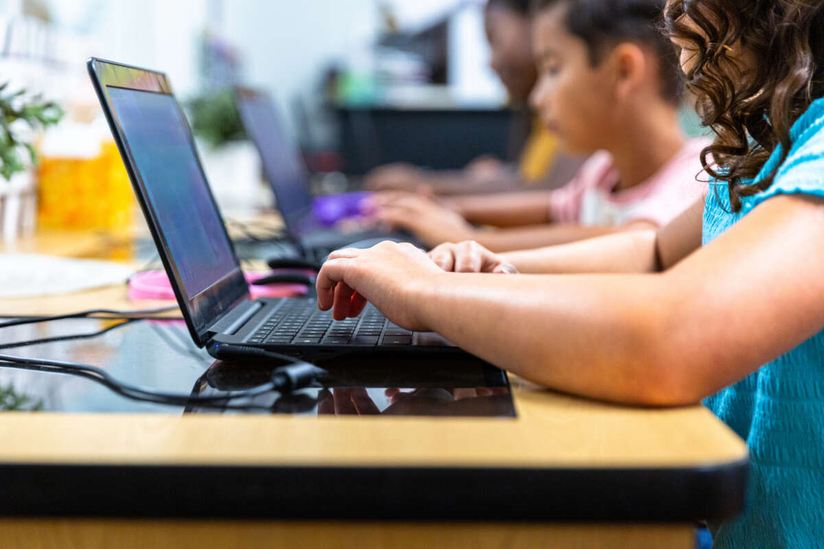 Elementary Students learning in the computer lab with their teacher - stock photo