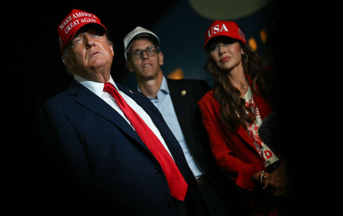 U.S. Secretary of Homeland Security Kristi Noem (R) watches U.S. President Donald Trump talk to journalists as they arrive at Joint Base Andrews, Maryland, early on July 4, 2025.