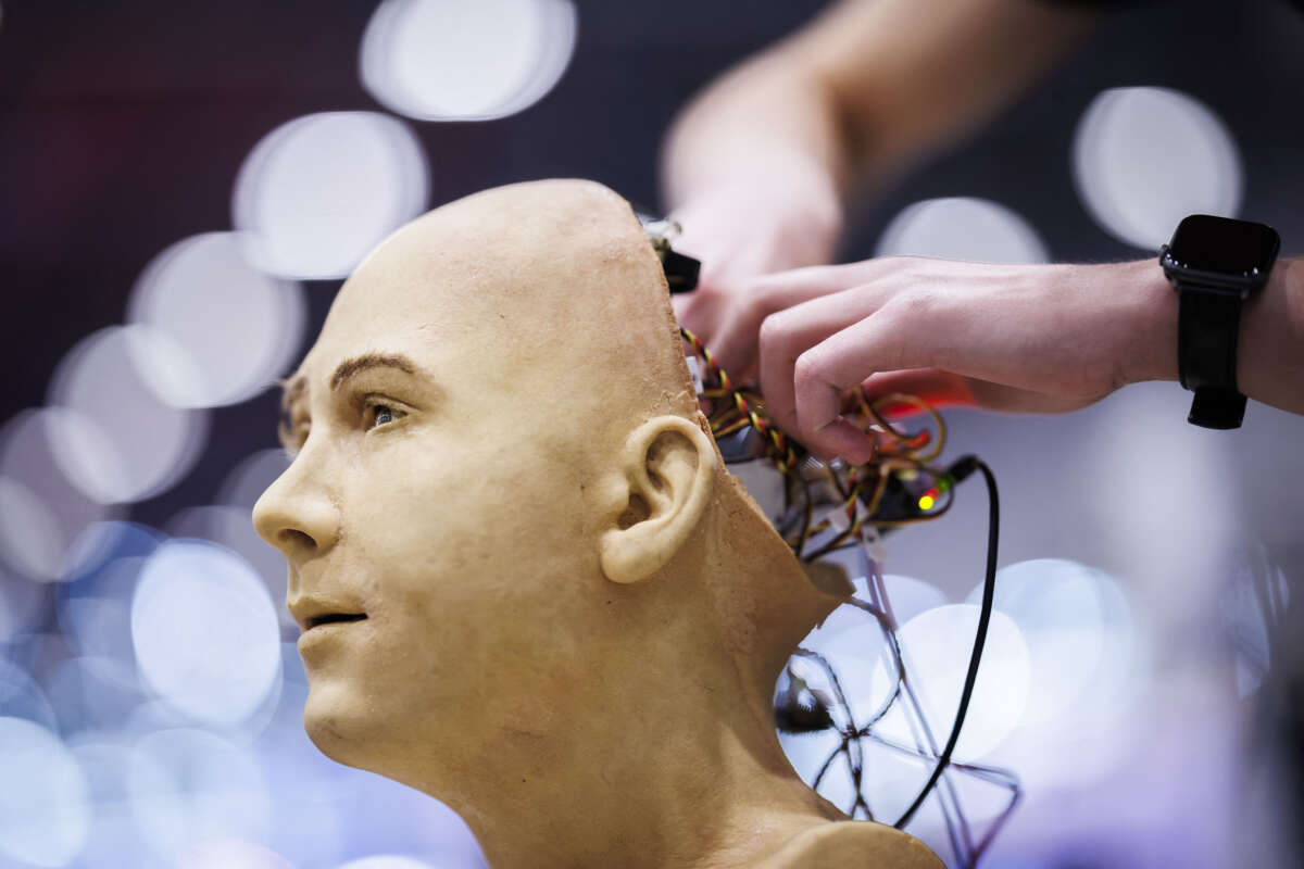 A man works on the electronics of Jules, a humanoid robot from Hanson Robotics that uses artificial intelligence, at a stand during the International Telecommunication Union (ITU) AI for Good Global Summit in Geneva, Switzerland, on July 8, 2025.