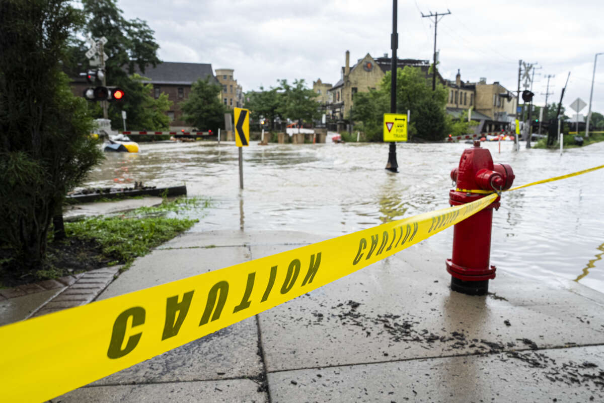 Caution tape marks off a pedestrian pathway from flooding on August 10, 2025, in downtown Wauwatosa, Wisconsin.
