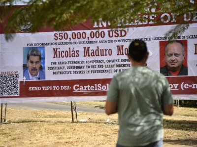 A man looks at a banner offering a reward for information leading to the arrest of Venezuelan President Nicolas Maduro and Venezuela's Minister of Interior Relations, Justice, and Peace, Diosdado Cabello, in Villa del Rosario, Norte de Santander Department, Colombia, on August 23, 2025.