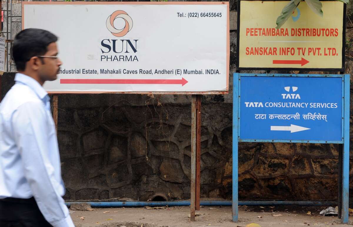A person walks past a Sun Pharma signboard in Mumbai, India, on April 7, 2014.