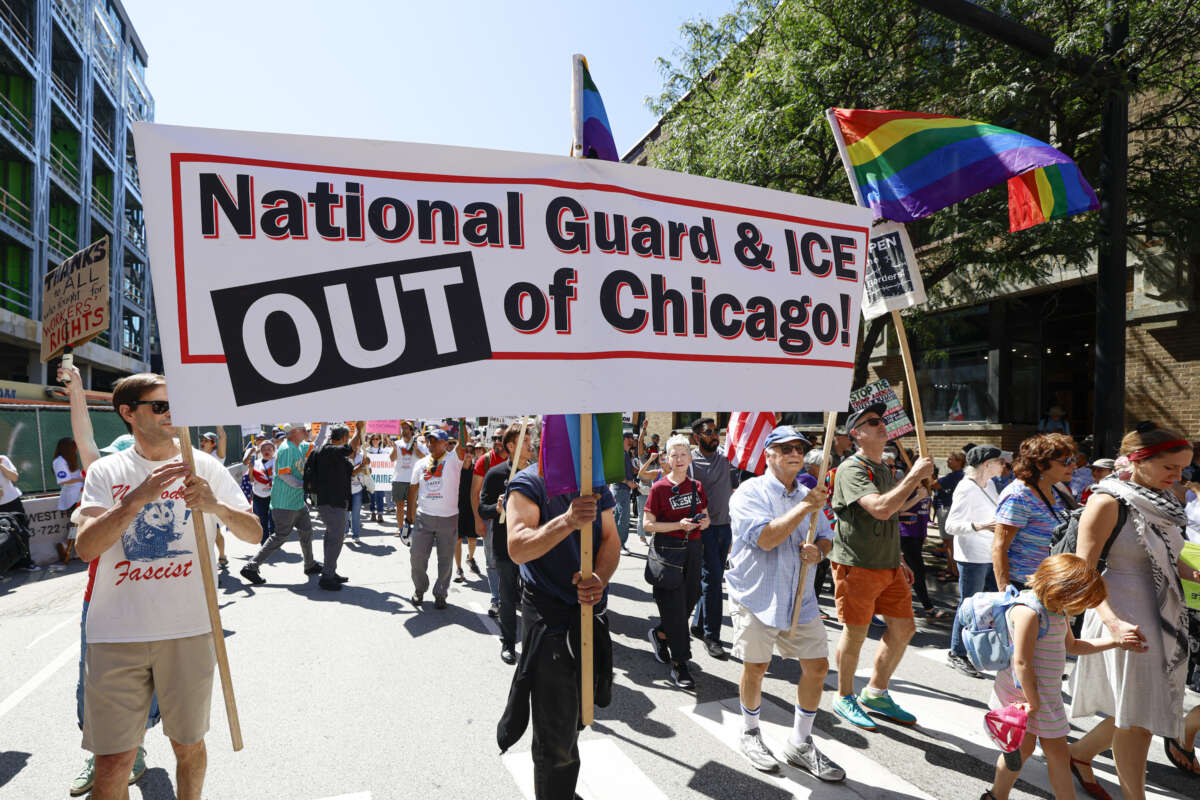 Protesters hold signs as they march during a "Workers over billionaires" rally on Labor Day in Chicago on September 1, 2025.