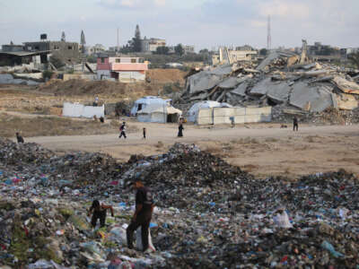 People sift through the rubbish near tents and makeshift shelters at the Bureij camp for Palestinian refugees in the Gaza Strip on September 21, 2025.