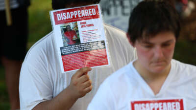 People reenact detentions at Centro de Confinamiento del Terrorismo (CECOT) during the "Good Trouble Lives On" rally and protest march in Washington, D.C.