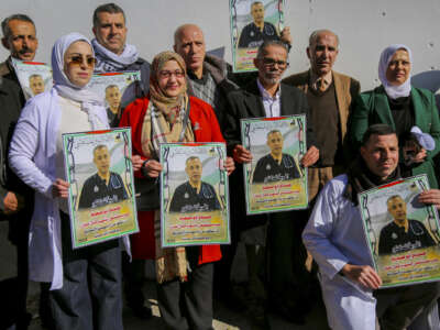 Protesters hold banners and photographs of Dr. Hossam Abu Safiya during a sit-in in Hebron in the Israeli-occupied West Bank, January 9, 2025.
