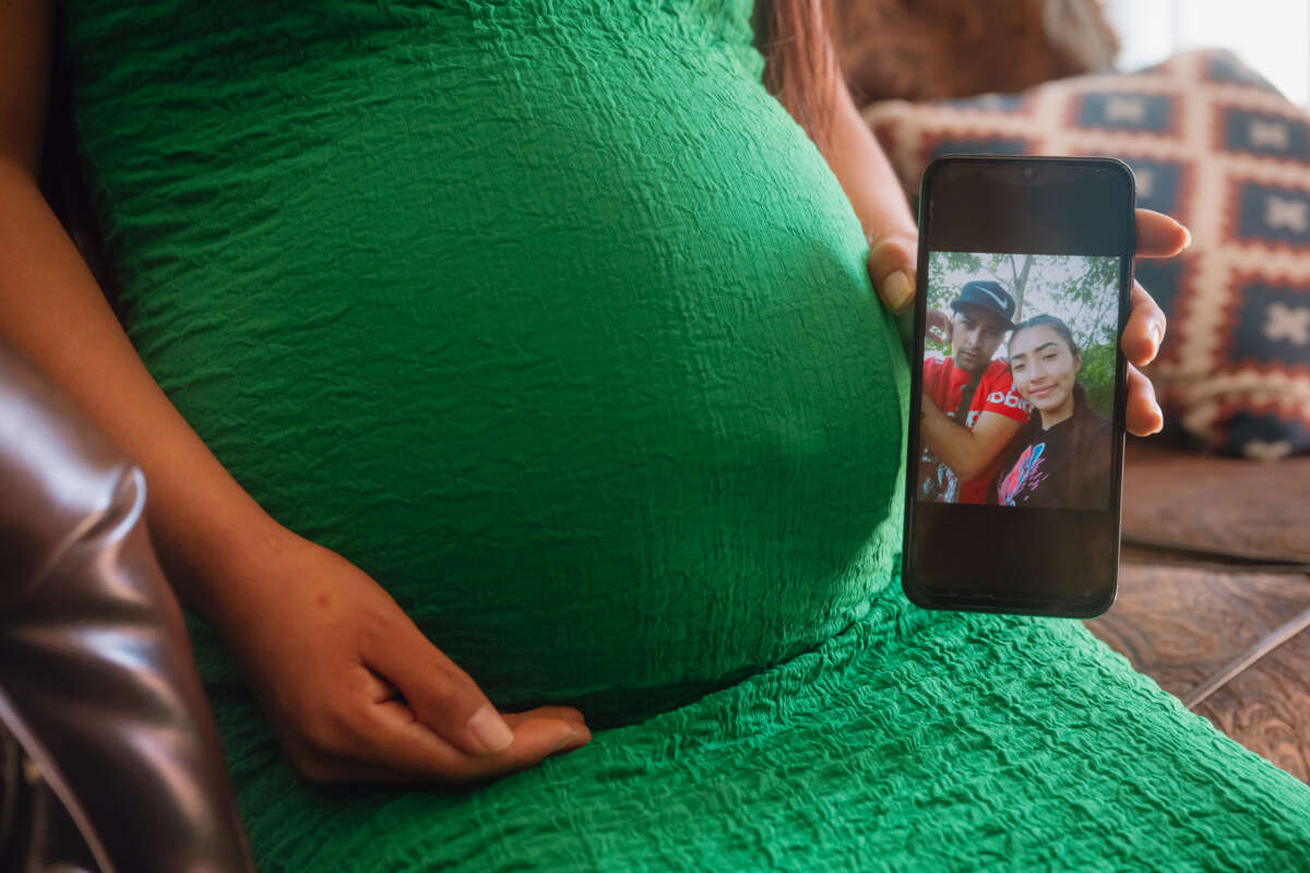 A pregnant woman in Dallas, Texas, shows a photograph of herself and her partner, who was recently detained by U.S. Immigration and Customs Enforcement (ICE) during a check-in, on March 20, 2025.