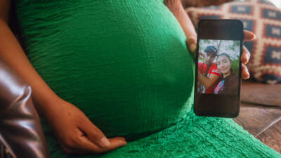 A pregnant woman in Dallas, Texas, shows a photograph of herself and her partner, who was recently detained by U.S. Immigration and Customs Enforcement (ICE) during a check-in, on March 20, 2025.