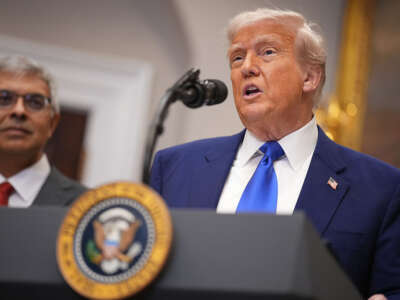 Donald Trump is standing at a podium with NIH director behind him.