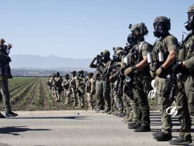 Federal agents block people protesting an ICE immigration raid at a nearby licensed cannabis farm on July 10, 2025, near Camarillo, California.