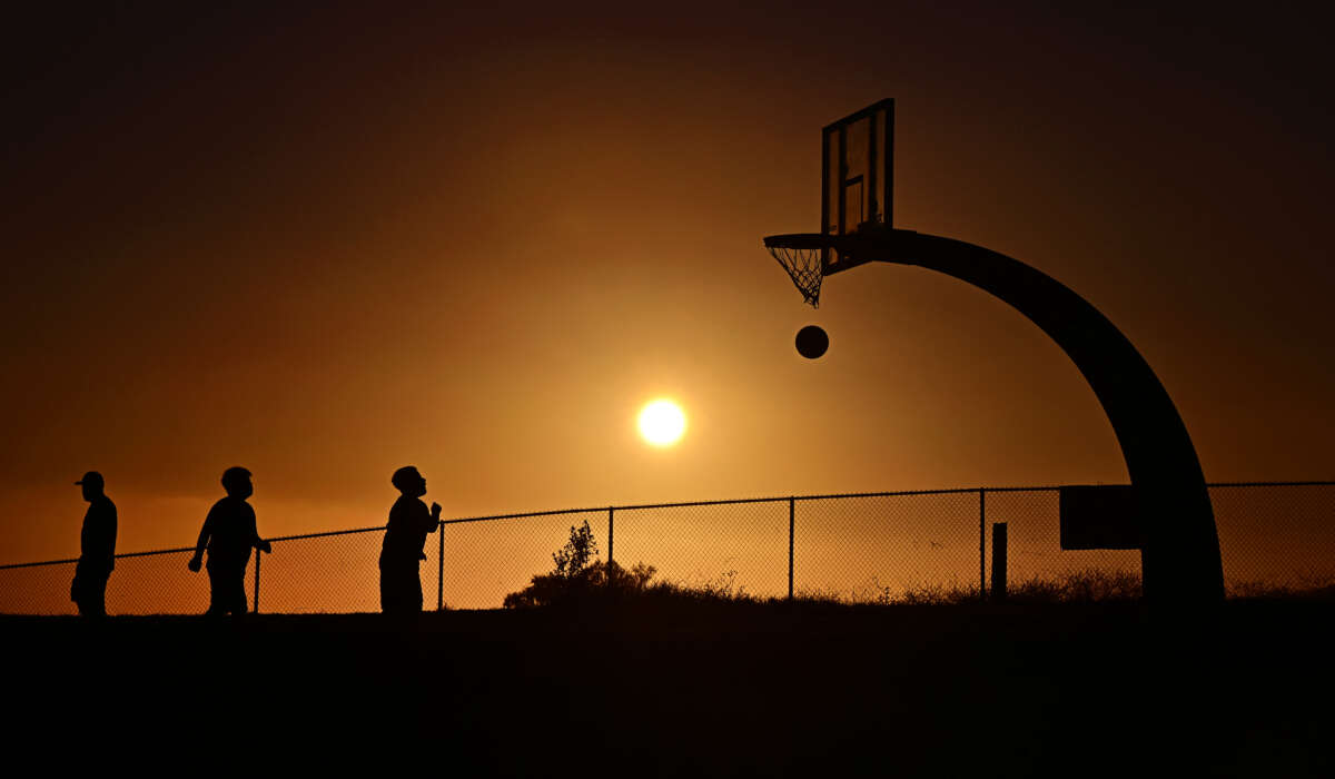 Children play basketball as the sun sets on August 19, 2025, in San Pedro, California after the National Weather Service issued an extreme heat warning for parts of Los Angeles County.