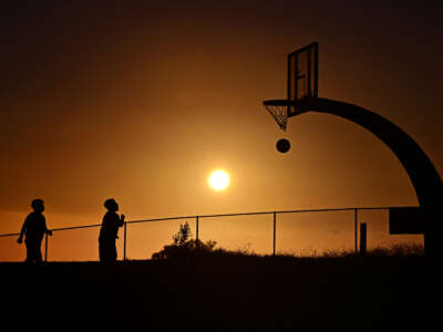 Children play basketball as the sun sets on August 19, 2025, in San Pedro, California after the National Weather Service issued an extreme heat warning for parts of Los Angeles County.