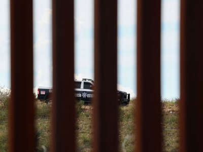 Close up of the border wall with a police car poking through