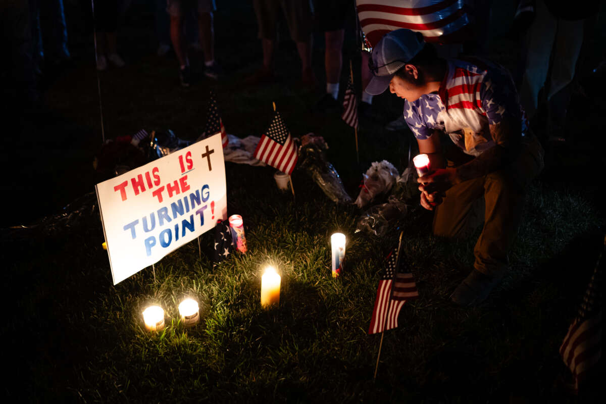 A person holds a candle in the memorial space during a Charlie Kirk vigil at Burlington Commons on September 17, 2025, in Burlington, Kentucky.
