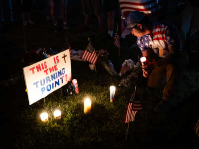 A person holds a candle in the memorial space during a Charlie Kirk vigil at Burlington Commons on September 17, 2025, in Burlington, Kentucky.