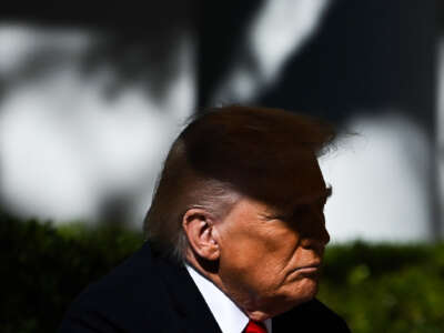 U.S. President Donald Trump listens to Senate Majority Leader John Thune, Republican of South Dakota, speak at a "Rose Garden Club" lunch in the Rose Garden of the White House in Washington, D.C., on October 21, 2025.