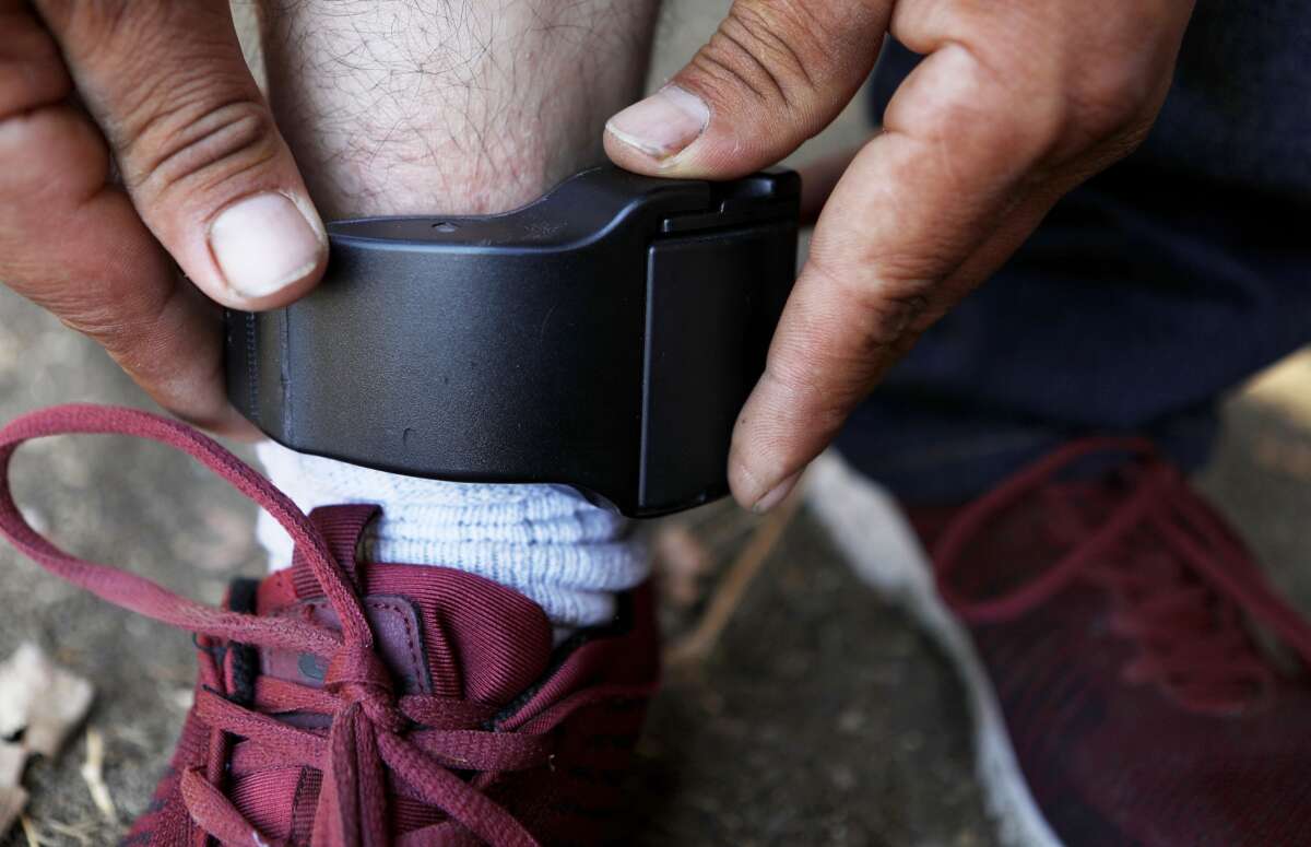 A migrant father from Guatemala, who chose not to be identified, demonstrates the ankle monitor he is required by ICE to wear 24 hours a day, on September 19, 2018, in Los Angeles, California.