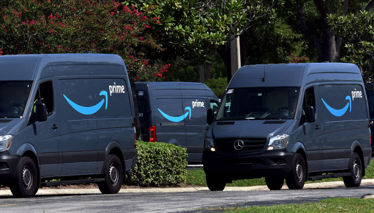 Amazon vans head to a distribution center to pick up packages for delivery on Amazon Prime Day on July 16, 2019, in Orlando, Florida.