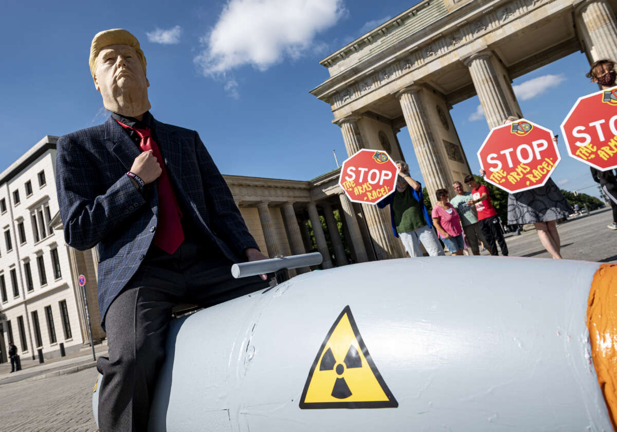 An activist disguised as U.S. President Trump drives in front of the Brandenburg Gate on a mobile model atomic bomb during a demonstration for a world without nuclear weapons in Berlin, Germany, on July 30, 2020.