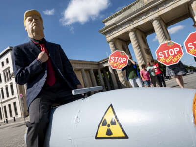 An activist disguised as U.S. President Trump drives in front of the Brandenburg Gate on a mobile model atomic bomb during a demonstration for a world without nuclear weapons in Berlin, Germany, on July 30, 2020.