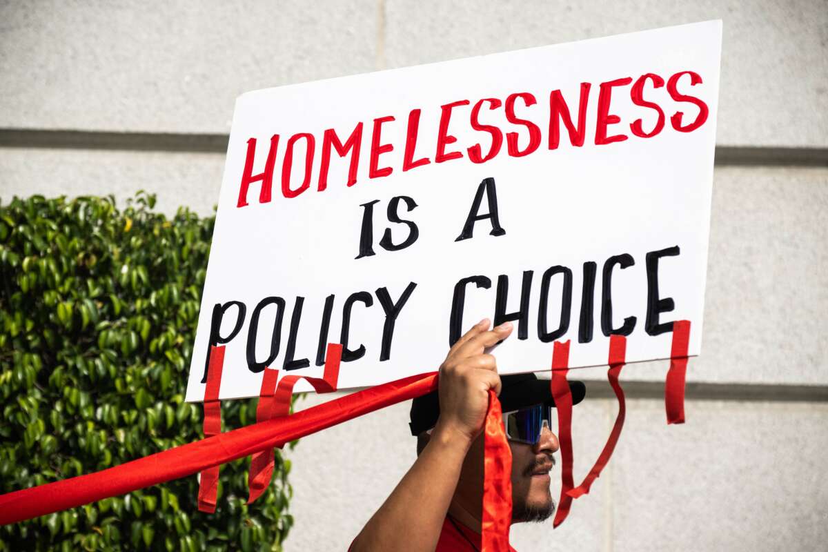 Housing advocates wrap red ribbons around Los Angeles City Hall to symbolize how red tape prevents affordable housing, on April 22, 2025.