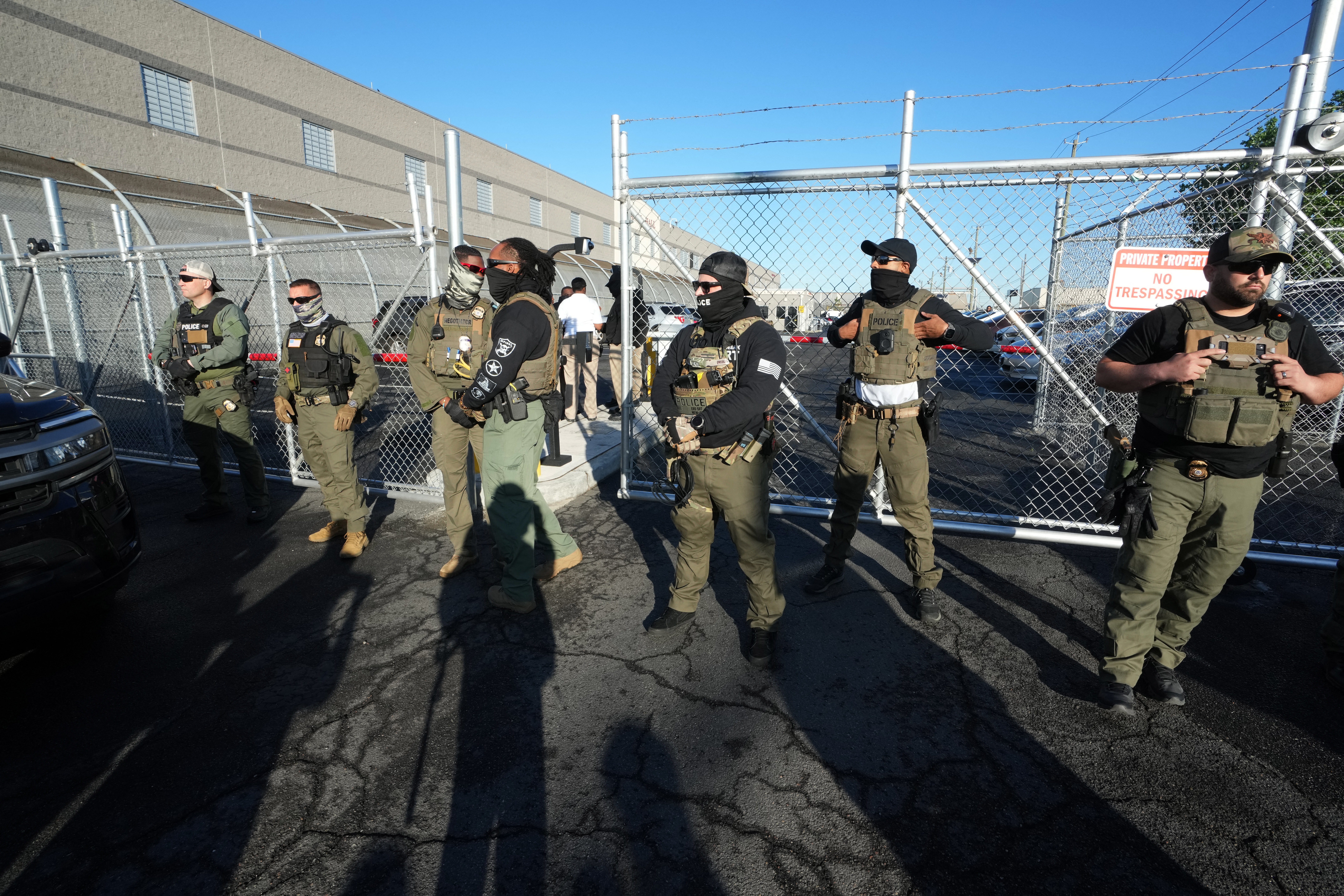 ICE agents stand near a gate at Delaney Hall, a newly converted immigrant detention center in Newark, New Jersey, on May 7, 2025. Delaney Hall is privately owned by the GEO Group.