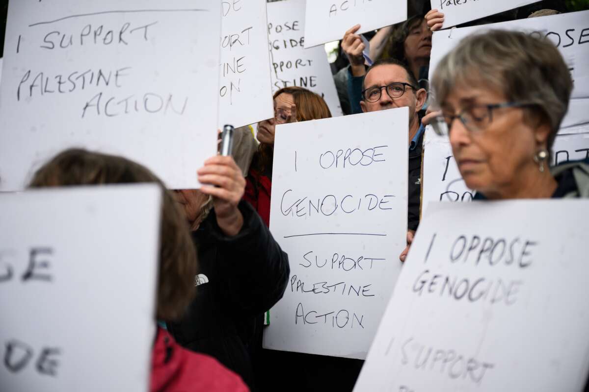 Supporters of Palestine Action hold placards before being arrested in Parliament Square after holding a small demonstration on July 19, 2025, in London, England.