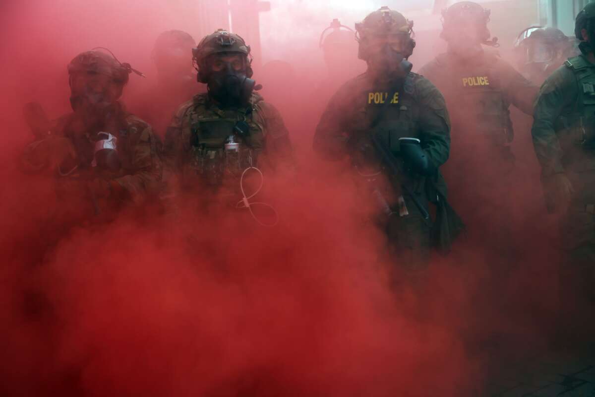 Federal agents deploy a smoke grenade outside a downtown U.S. Immigration and Customs Enforcement (ICE) facility on October 4, 2025, in Portland, Oregon. The facility has become a focal point of nightly protests against the Trump administration and his announcement that he will be sending National Guard troops into Portland.