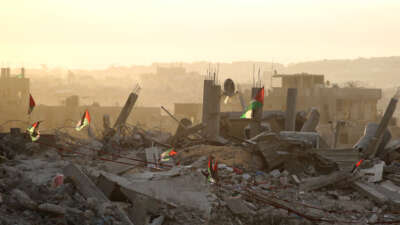 Palestinian flags flutter on top of rubble in Gaza City on October 12, 2025.