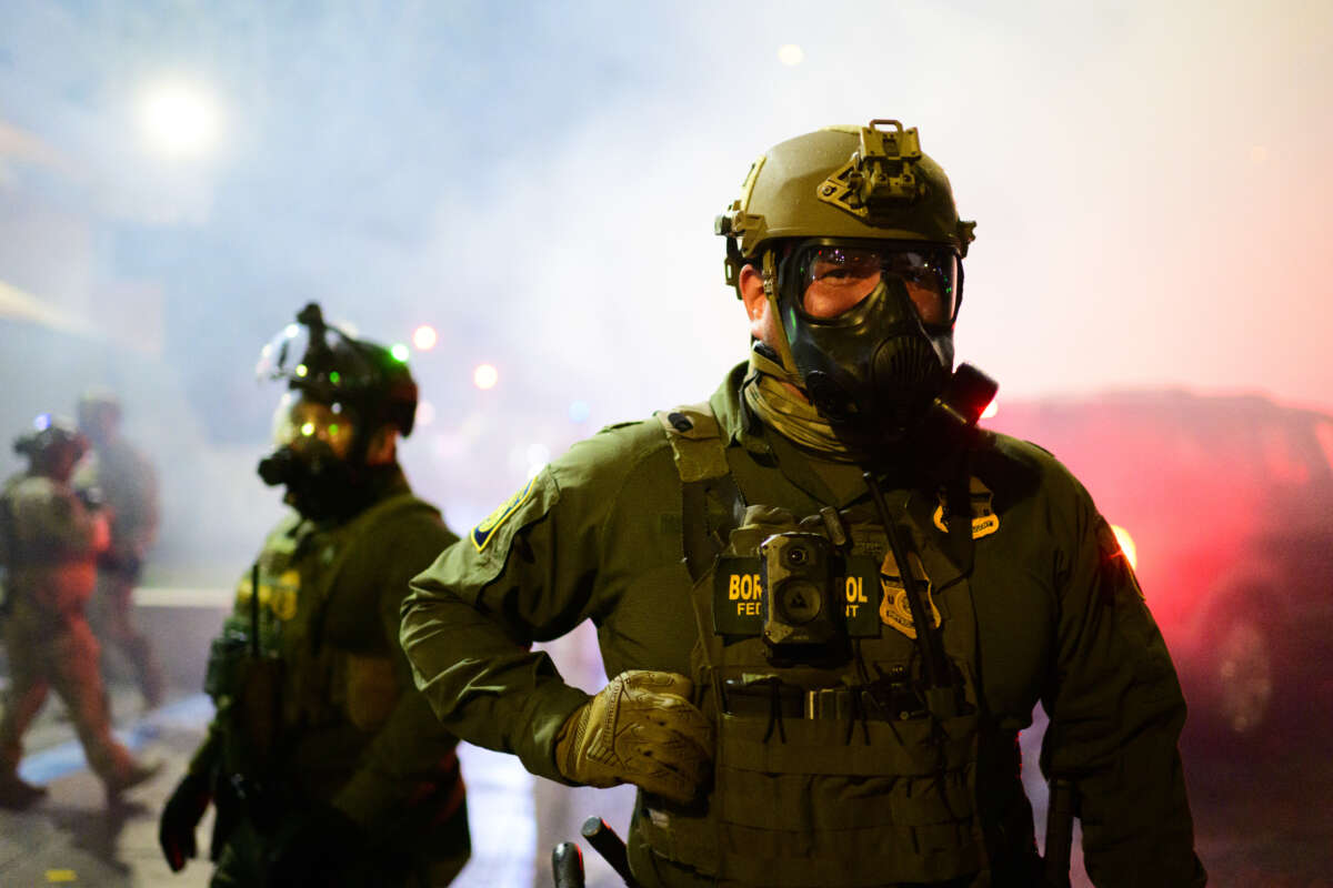Federal agents walk through tear gas at the U.S. Immigration and Customs Enforcement building on October 18, 2025, in Portland, Oregon.