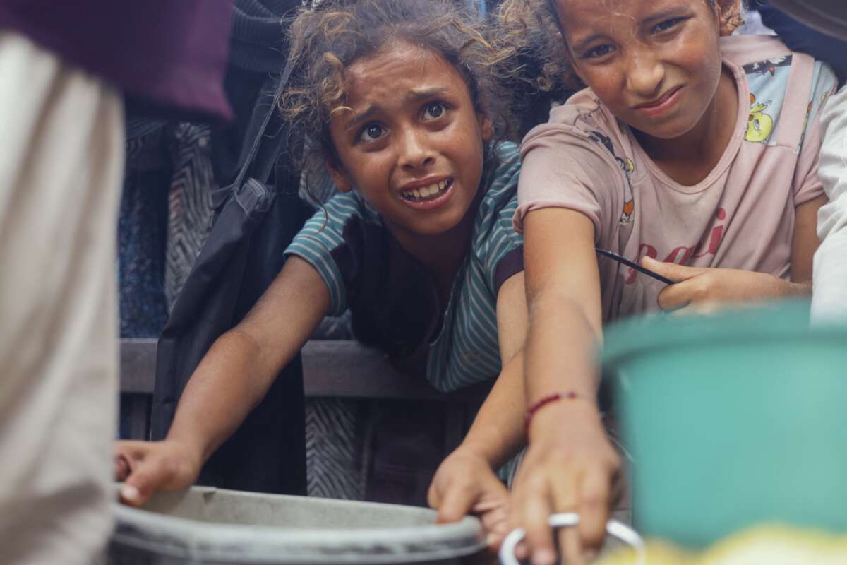 Displaced Palestinians wait in long lines for a charitable meal under crowded tents in Khan Yunis, Gaza, on October 21, 2025, as food scarcity worsens under Israel’s ongoing siege.