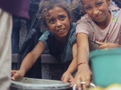Displaced Palestinians wait in long lines for a charitable meal under crowded tents in Khan Yunis, Gaza, on October 21, 2025, as food scarcity worsens under Israel’s ongoing siege.