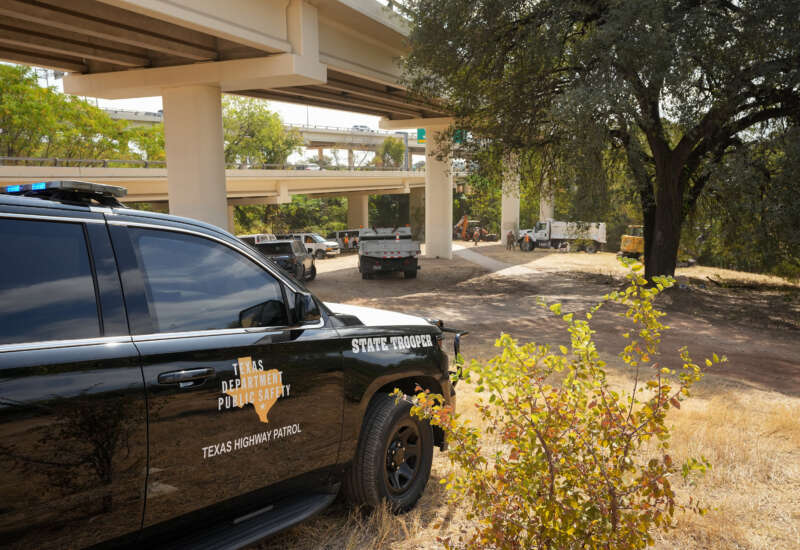 A Texas DPS vehicle is parked where Texas State Guard soldiers removed a homeless camp under the Mopac Expressway and West 5th Street interchange in Austin, Texas, on October 21, 2025.