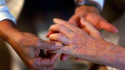 United HomeCare Services home health aide Wendy Cerrato massages the fingers of Olga Socarras during a visit on January 6, 2010, in Miami, Florida.