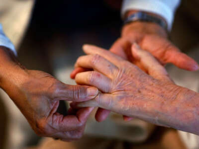 United HomeCare Services home health aide Wendy Cerrato massages the fingers of Olga Socarras during a visit on January 6, 2010, in Miami, Florida.