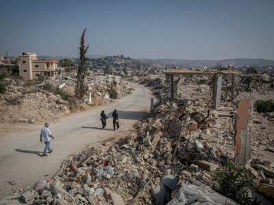 Visiting residents walk down a street in the mostly destroyed Lebanese village of Ayta al-Shaab November 7, 2025.