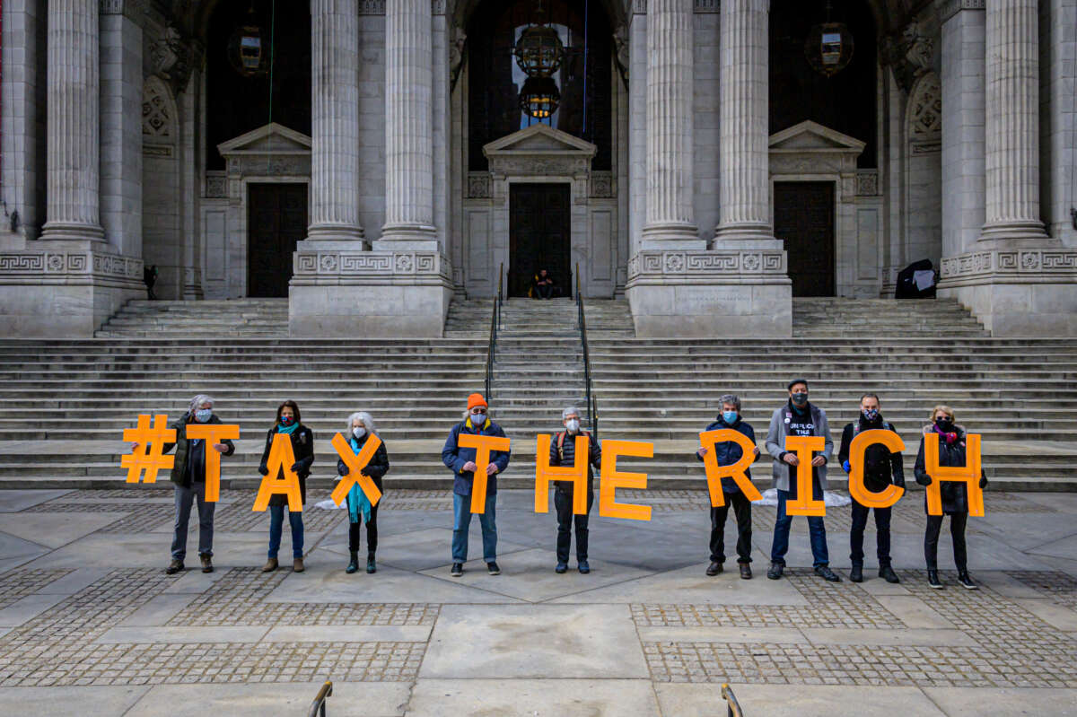 People spell out #TaxTheRich at the New York Public Library in New York City in March 2021.