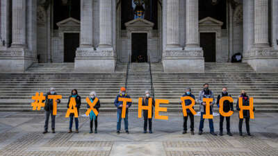 People spell out #TaxTheRich at the New York Public Library in New York City in March 2021.