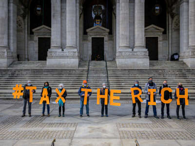People spell out #TaxTheRich at the New York Public Library in New York City in March 2021.
