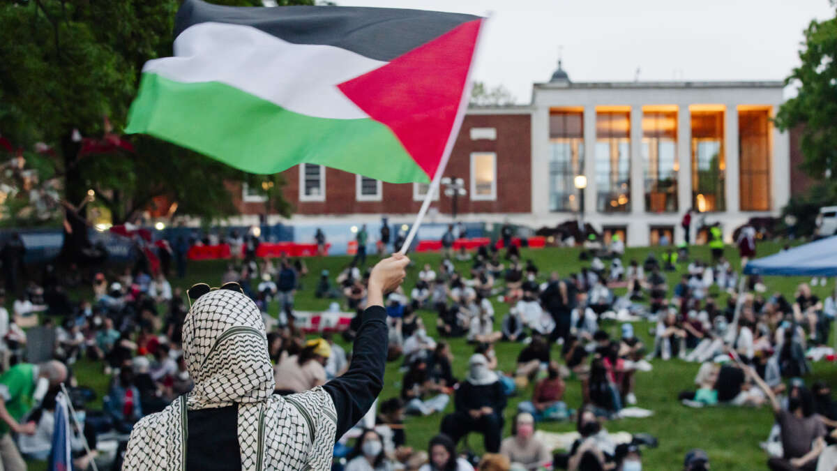 A protester waves a Palestinian flag in front of a few hundred students gathered to protest the genocide in Gaza at the Johns Hopkins University Homewood Campus on April 30, 2024, in Baltimore, Maryland.