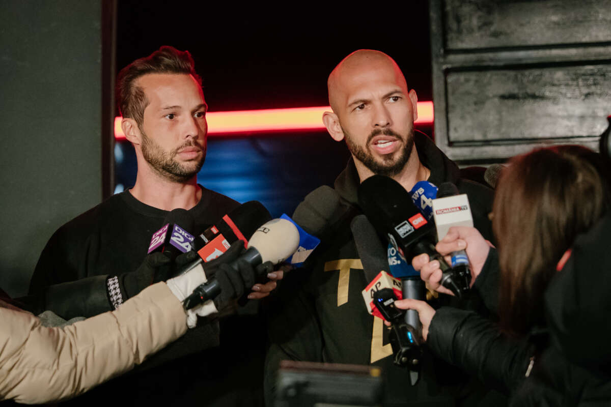 Andrew Tate and his brother Tristan Tate talk to the media outside their residence on March 23, 2025 in Bucharest, Romania.
