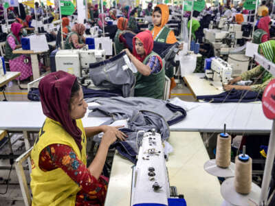 Garment workers tailor clothes at their sewing stations in a garment factory in Tongi, on the outskirts of Dhaka, Bandladesh, on July 6, 2025.
