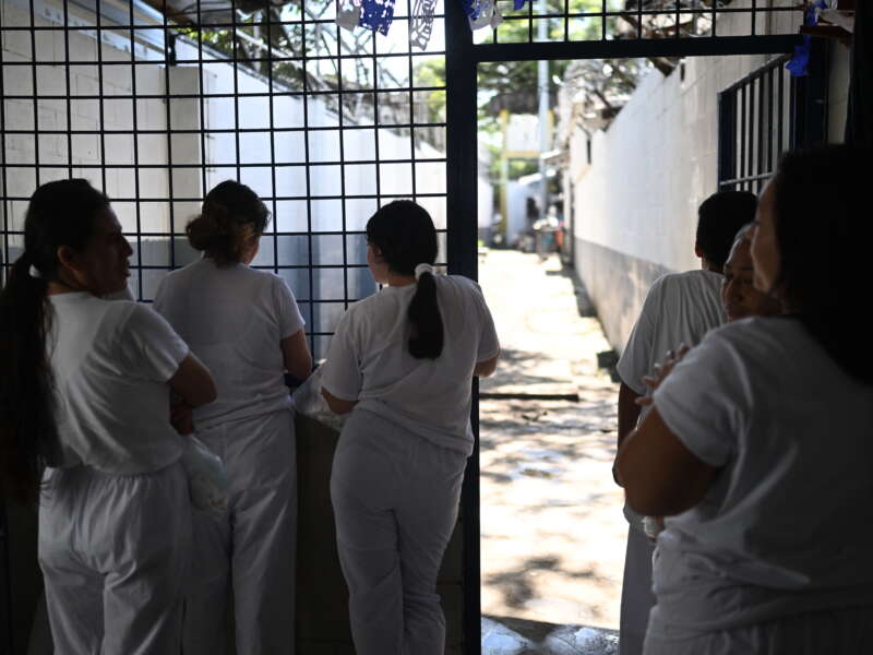 Incarcerated women look out from a gate during the celebration of the 204th anniversary of El Salvador's independence at the Apanteos prison in Santa Ana, El Salvador, on September 30, 2025.