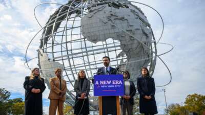 Mayor-elect of New York City Zohran Mamdani stands alongside members of his transition team as he speaks during a press conference at the Unisphere in Flushing Meadows Corona Park on November 5, 2025, in the Queens borough of New York City.
